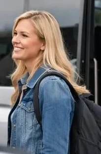 Sarah, smiling, with her backpack at the airport shuttle